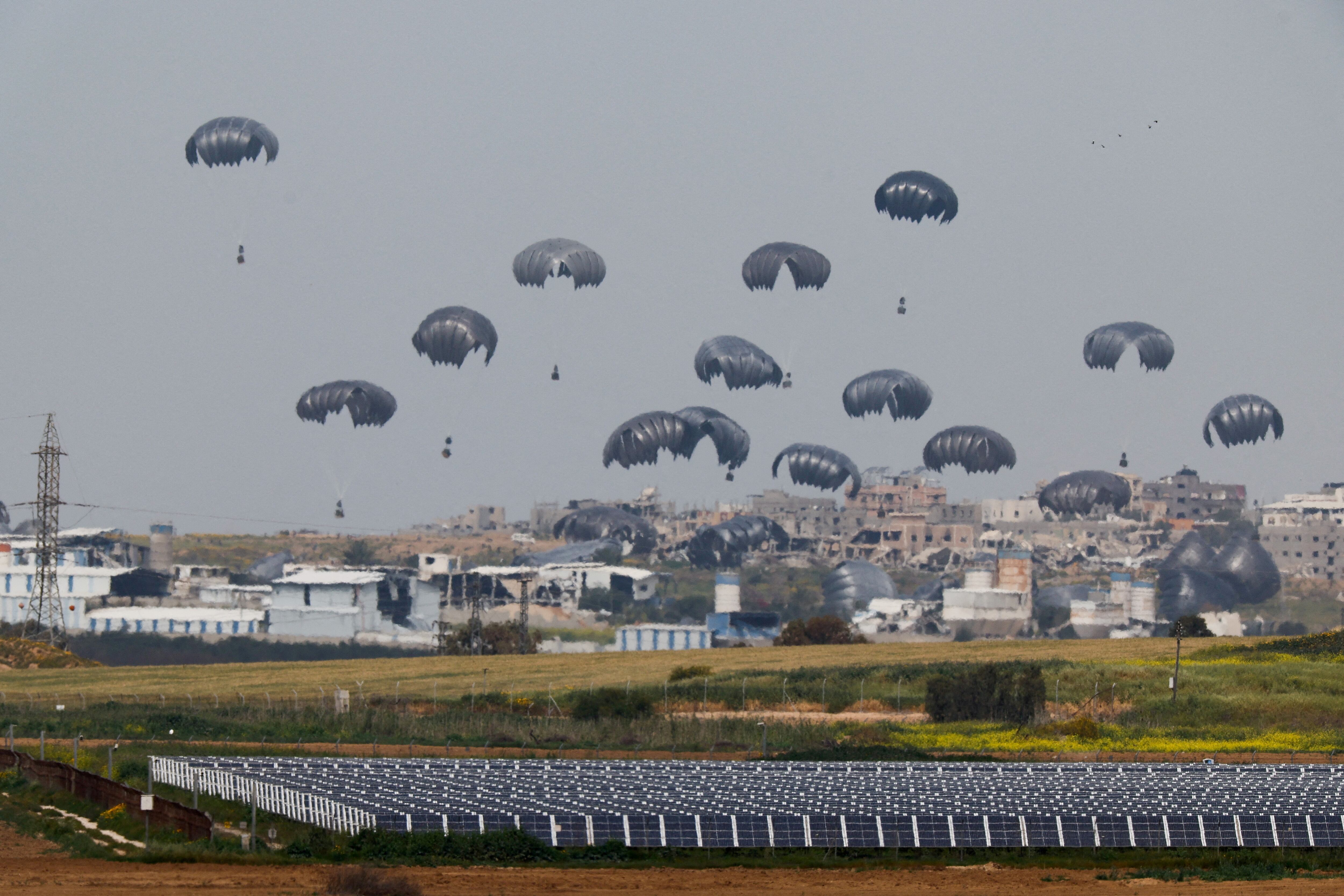 Humanitarian aid falls through the sky towards the Gaza Strip after being dropped from an aircraft, amid the ongoing conflict between Israel and the Palestinian Islamist group Hamas, as seen from Israel's border with Gaza, in southern Israel, March 17, 2024. REUTERS/Amir Cohen     TPX IMAGES OF THE DAY