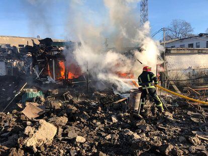 Un bombero trata este lunes de apagar el incendio en el edificio destruido por un bombardeo ruso en la localidad de Shevchenkove, en Járkov.