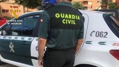 Un agente de la Guardia Civil junto a su vehículo.