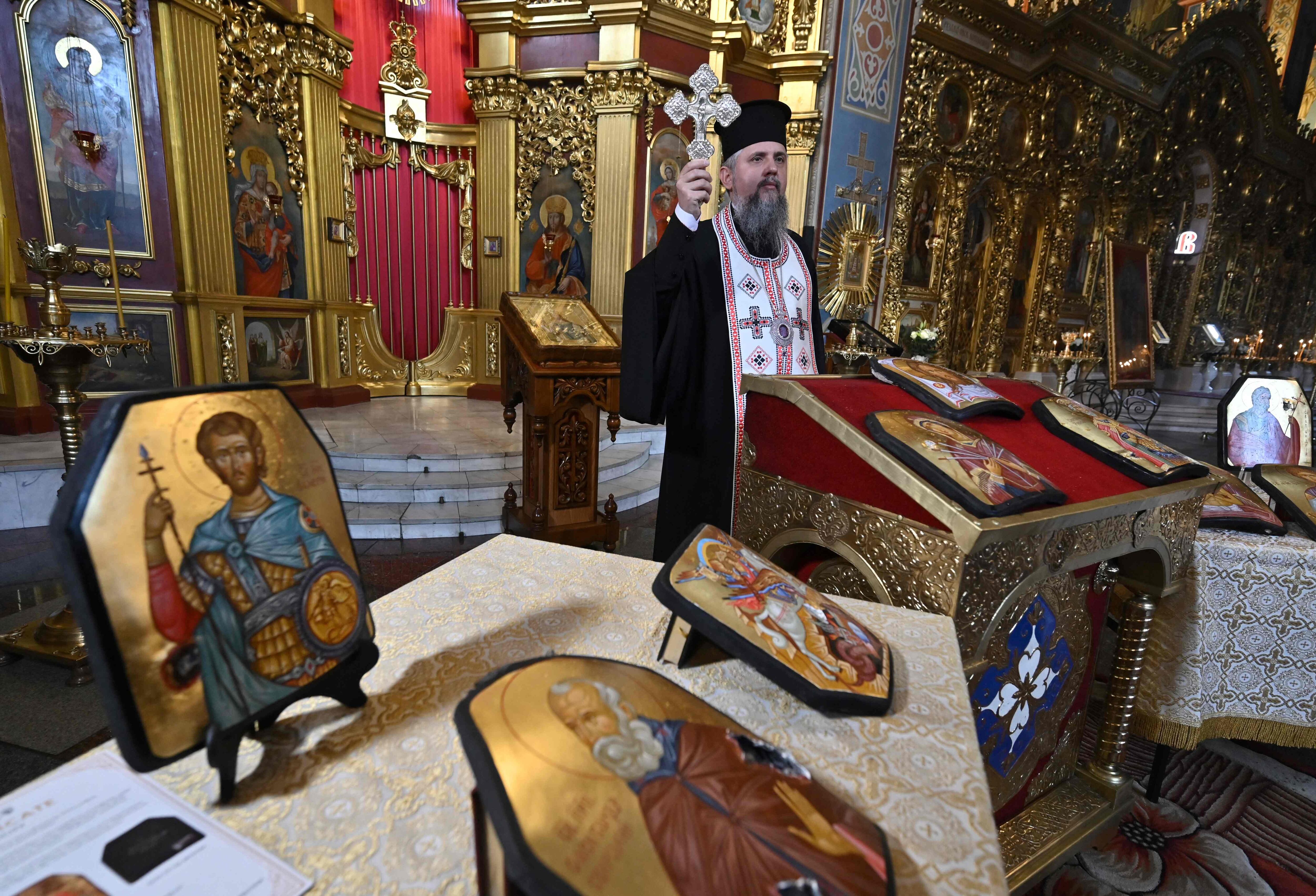 Metropolitan Epiphanius, head of the Ukrainian Orthodox Church takes part in a ceremony of consecration of icons painted on plates from bulletproof vests used by Ukrainian servicemen at St. Michael's Golden-Domed Cathedral in Kyiv on May 23, 2023, amid the Russian invasion of Ukraine. Twelve icons from the cycle "Spiritual Valor" within the framework of the �ArtArmor� project are painted on bullet-scarred armored plates from bullet proof vests that saved the lives of Ukrainian soldiers. (Photo by Genya SAVILOV / AFP)