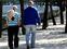 Dos personas de avanzada edad pasean por un parque de Madrid.