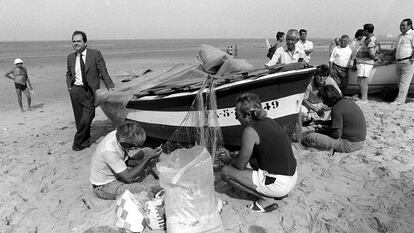 Manuel Chaves, junto a unos pescadores en la playa de la Victoria, en Cádiz, durante la campaña electoral en junio de 1990.