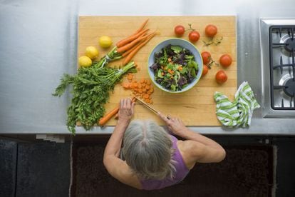 Una mujer prepara una ensalada con verduras, integrantes de la dieta mediterránea.