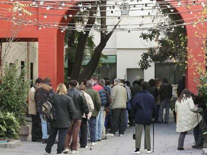 Un grupo de personas sin hogar aguarda para acceder al comedor del centro de acogida de San Isidro (Madrid).