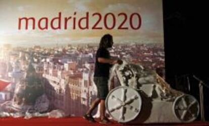 Un operario retira una réplica de la Cibeles de un escenario tras la derrota de Madrid en la carrera olímpica.