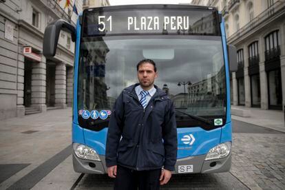 El conductor de la EMT Rubén posa junto al autobús que conduce en la Puerta del Sol (Madrid).