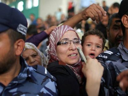 Una mujer con su hijo pide un visado en Gaza para cruzar a Egipto.