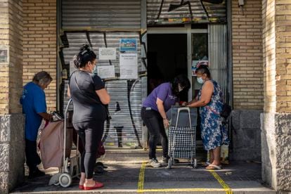 Varias personas acuden a un banco de alimentos en julio en el barrio de Orcasitas, Madrid.