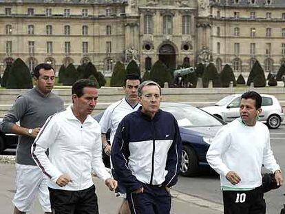 El presidente colombiano, Álvaro Uribe, corre rodeado de guardaespaldas ante Los Inválidos, en París.