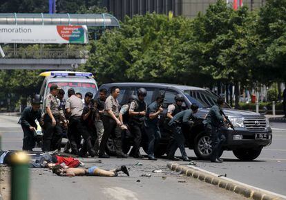Agentes se protegen tras un coche despu&eacute;s de un atentado suicida en Yakarta, cuyo autor&iacute;a reclam&oacute; el ISIS, el 14 de enero de 2016.