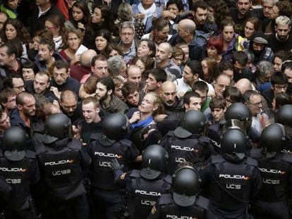 Agentes antidisturbios de la Policía Nacional forman un cordón de seguridad en los alrededores del colegio Ramón Llull de Barcelona.
