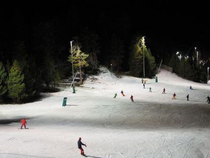 Esquiadores en la estación de La Masella, iluminada por la noche.