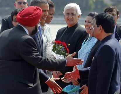 El presidente de EE UU, junto a su mujer, saluda a las autoridades de la capital financiaera india que han acudido a recibirles.