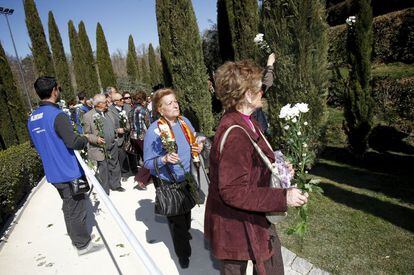 Varias personas con flores en el homenaje de Asociación de Víctimas del Terrorismo a las víctimas del 11-M en el séptimo aniversario del atentado, en el Bosque de los Ausentes del parque del Retiro de Madrid. Marzo de 2011.