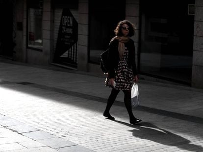 Una mujer pasea por la calle Preciados.