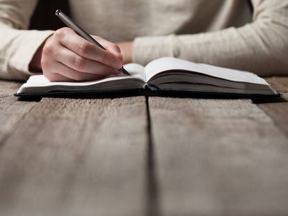 Una mujer escribe en un cuaderno.