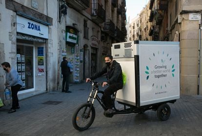 Un repartidor distribuye pan congelado para supermercados de Ciutat Vella con una bicicleta de carga eléctrica.