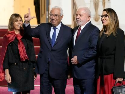 El primer ministro portugués, António Costa, observado por su esposa Fernanda Tadeu, hace el gesto de apoyo a Lula a la llegada del político brasileño al palacio de São Bento acompañado de su esposa Rosangela da Silva.