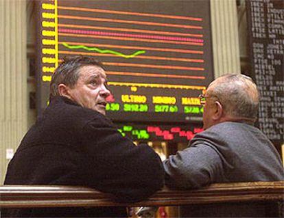 Dos <i>brokers</i> contemplan con preocupación las cotizaciones en la Bolsa de Madrid.