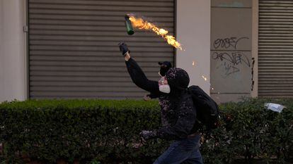 Un manifestante lanza un cóctel molotov contra la policía, este jueves en Atenas.