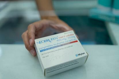 Una farmacéutica sostiene una caja de Neobrufen, un medicamento que combina ibuprofeno con codeína.