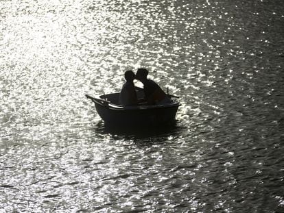 Una pareja se besa en una barca en el parque de El Retiro de Madrid. 