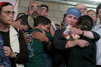 Miembros de la familia del colono Eliyahu Asheri se abrazan durante el funeral ayer en Jerusalén.