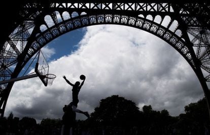 Varias personas juegan al baloncesto debajo de la Torre Eiffel durante la visita de los miembros de la Comisión de Coordinación del Comité Olímpico Internacional (COI) a París.