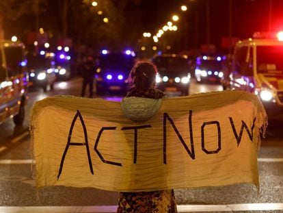 Una mujer sostiene una manta con la frase "Actúen ahora", durante una cumbre climática de Naciones Unidas.