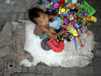 Un ni&ntilde;o sin hogar y sus juguetes recogidos por sus padres en las calles de Manila, Filipinas.