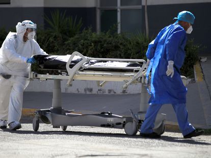 Personal médico traslada el cuerpo de un fallecido por covid-19 hoy en el Hospital General en Ciudad Juárez (México).