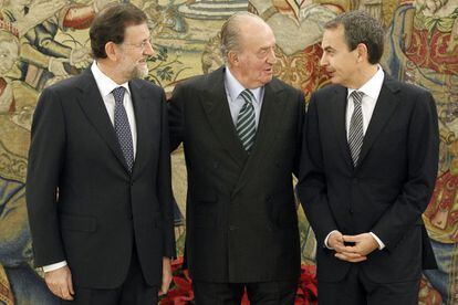 El rey Juan Carlos conversa con el jefe del Ejecutivo saliente, José Luis Rodríguez Zapatero(d) junto al líder del PP, Mariano Rajoy, durante el acto celebrado en el Palacio de la Zarzuela en el que este ha jurado el cargo de presidente del Gobierno.