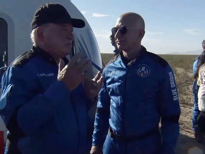 El actor William Shatner, a la izquierda, habla con Jeff Bezos al bajarse de la nave espacial cerca de Van Horn, Texas.