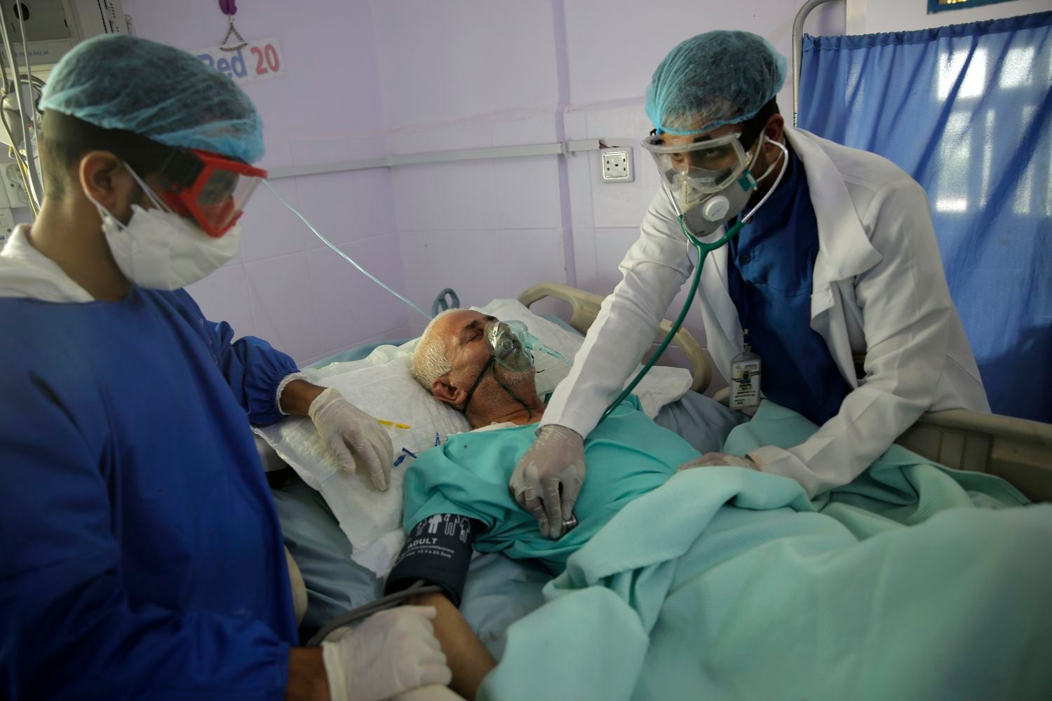 Dos sanitarios tratan a un enfermo de covid en Yemen.