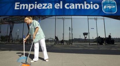 Una limpiadora frente al Palacio de Congresos de Málaga donde el Partido Popular celebra la convención.