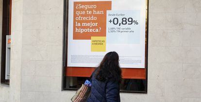 Una mujer mira una publicidad de hipoteca en Madrid.