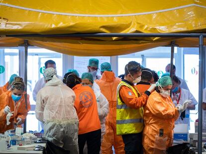 Las adjudicaciones de emergencia son la vía más utilizada para contratar material para hacer frente al covid-19. En la imagen, sanitarios en un puesto de vestido y desvestido y desinfección a la entrada del Hospital de Campaña de Ifema.