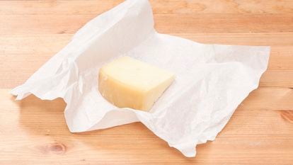 Un trozo de queso envuelto en papel.