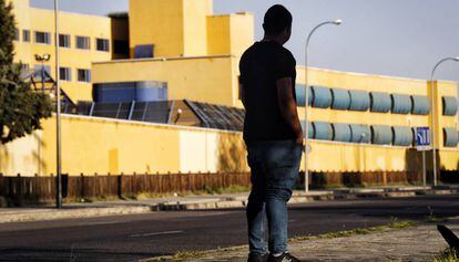 Un joven ghanés, que pasó 49 días internado en el CIE de Aluche (Madrid), observa el centro desde el exterior.