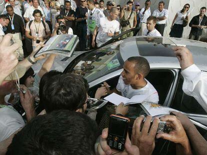 Lewis Hamilton firma autógrafos a la salida del circuito de Melbourne.