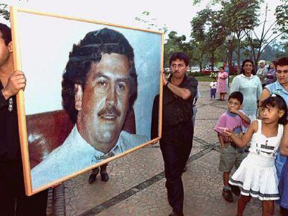 Dos hombres llevan un retrato de Escobar en el aniversario de su muerte. 