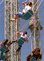Sillas voladoras y La Venganza del Enigma, la torre de caída libre más alta de Europa, en el Parque Warner de Madrid.