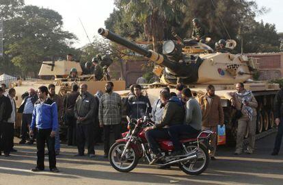 Un grupo de partidarios de los Hermanos Musulmanes, junto a los tanques que vigilan los muros del palacio presidencial de El Cairo.