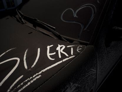 La palabra "suerte" escrita en un coche cubierto de ceniza en Tajuya, La Palma.