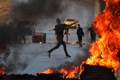 Un manifestante palestino lanza piedras contra soldados israelíes durante los enfrentamientos en la ciudad de Ramallah,  Cisjordania.