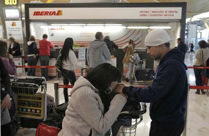 Un grupo de pasajeros ante un mostrador de Iberia en el aeropuerto de Barajas.