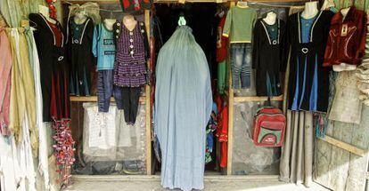 Una mujer cubierta por el burka entra en una tienda en Qala-i-Naw, Afganist&aacute;n.