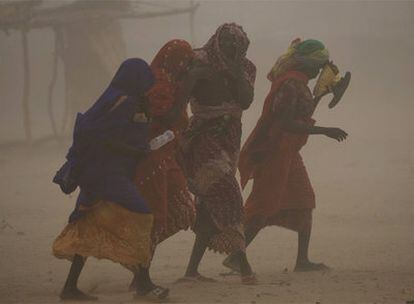 Cuatro refugiadas caminan en medio de una tormenta de arena el jueves cerca de Goz Beida.