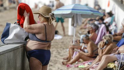 Numerosas personas disfrutan del buen tiempo en la playa de Levante de Benidorm, en Alicante, este enero.