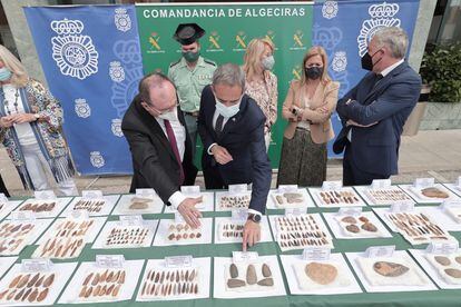 El catedrático de Prehistoria, José Ramos, muestra el subdelegado del Gobierno en Cádiz, José Pacheco, parte de los mil útiles prehistóricos recuperados en una operación de la Guardia Civil y la policía en Algeciras.